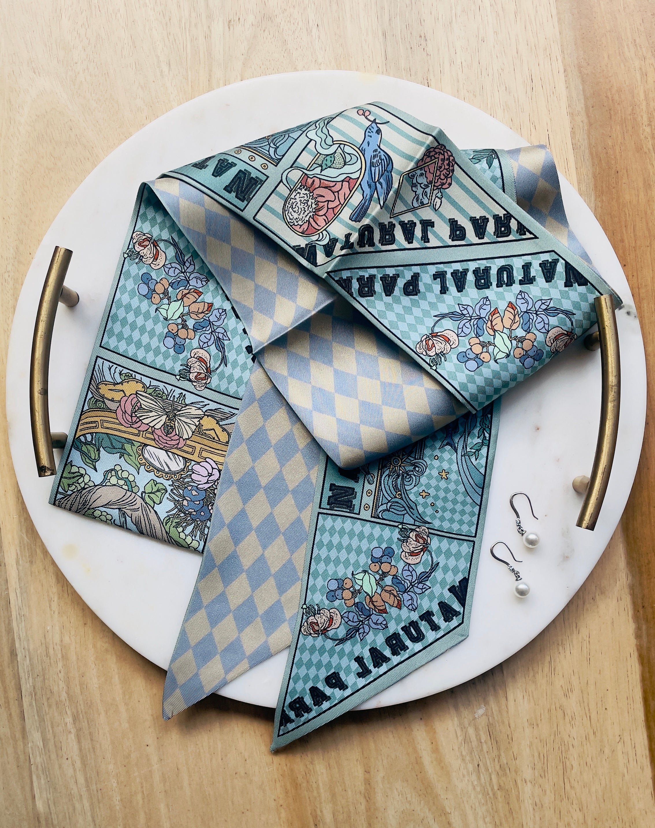 Enchanted Trail Silk Twilly Folded Scarf with whimsical animals, plants, and florals